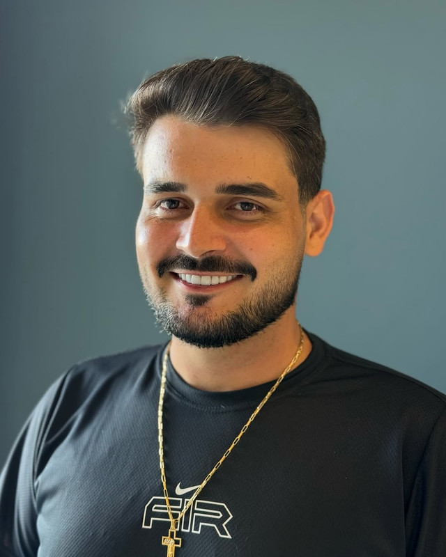Cliente satisfeito mostrando seu novo corte de cabelo na cadeira da barbearia.